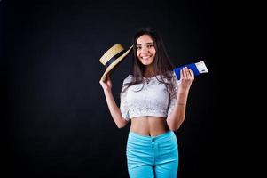 retrato de una mujer feliz posando con pasaporte y sombrero. foto