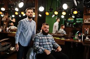 Handsome bearded man at the barbershop, barber at work. photo