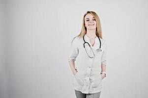 Blonde doctor nurse with stethoscope isolated on white background. photo
