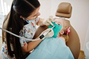 Little baby girl at dentist chair. Children dental. photo