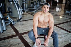 hombre árabe en forma y musculoso haciendo ejercicios en el gimnasio. foto