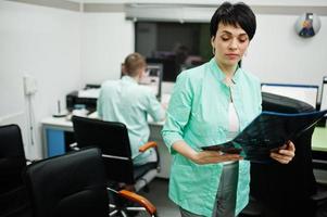 Medical theme. Female doctor hold x-ray in the mri office at diagnostic center in hospital. photo