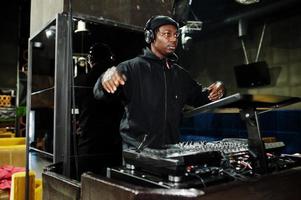 African american dj play music on decks at night club. photo