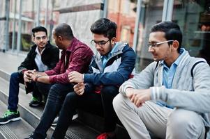 Group of four indian teen male students. Classmates spend time together. photo