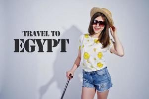 Girl tourist with bag, wear in shirt, shorts and hat with glasses isolated on white. Travel to Egypt. photo