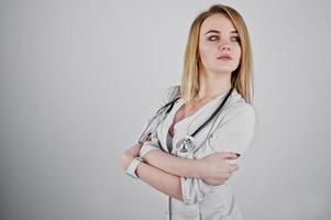 Blonde sexy doctor nurse with stethoscope isolated on white background. photo