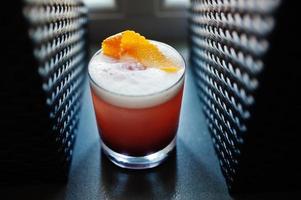 Alcoholic rose cocktail in glass at bar table. photo