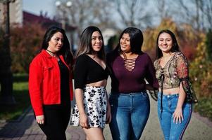 Group of four happy and pretty latino girls from Ecuador posed at street. photo