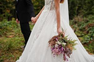 Bride and groom holding beautiful tender wedding bouquet. photo