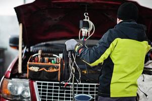 El mecánico de automóviles establece un automóvil suv americano para diagnóstico y configuración en la estación de servicio del taller. foto