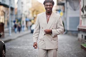 Stylish afro man in beige old school suit. Fashionable young African male in casual jacket on bare torso. photo