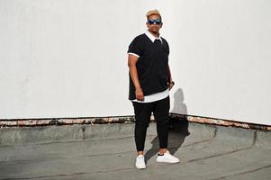 Stylish arabian muslim boy with originally hair and sunglasses posed on streets at roof. photo