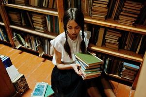 Girl with pigtails in white blouse at old library. photo