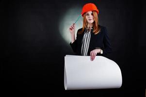 mujer ingeniera en casco de protección naranja con proyecto de papel de construcción. foto