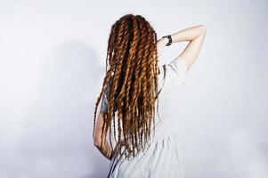 sesión de estudio de una chica vestida de gris con rastas sobre fondo blanco. foto