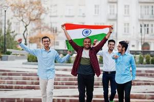 grupo de cuatro hombres indios del sur de asia con bandera india. foto