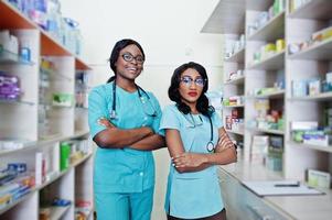 Two african american pharmacist working in drugstore at hospital pharmacy. African healthcare. photo