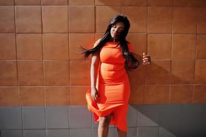 mujer afroamericana modelo xxl en vestido naranja. foto