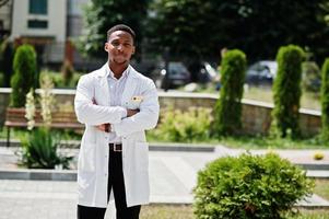 African american doctor male at lab coat with stethoscope outdoor. photo