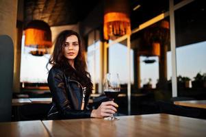 joven mujer rizada disfrutando de su vino en un bar. foto