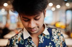 Close up portrait of young male indian freelancer in fast food cafe, handsome head of asian man wear in shirt at comfortable coffee shop. photo