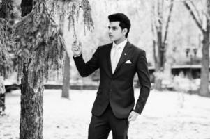 Elegant indian macho man model on suit and pink tie posed on winter day. photo