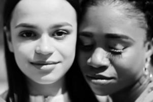 cierra las caras de una chica caucásica blanca y afroamericana negra juntas. unidad mundial, amor racial, comprensión en la tolerancia y cooperación en la diversidad de razas. foto
