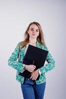 chica rubia con estilo en chaqueta y jeans con diario de cuaderno y portátil en las manos contra fondo blanco en el estudio. foto