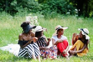 Group of african american girls celebrating birthday party and eat muffins outdoor with decor. photo