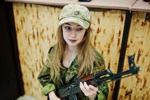 Girl with machine gun at hands on shooting range. photo