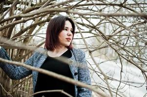 Portrait of brunette girl in black dress at spring wood. photo