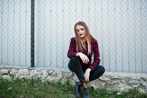 Young hipster girl in checkered shirt posed outdoor. photo