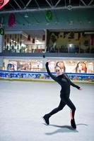 Figure skater woman at ice skating rink. photo