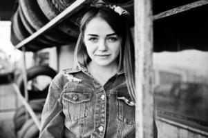 Young hipster girl in jeans jacket and head scarf at tire fitting zone. photo