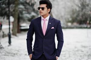 Elegant indian macho man model on suit and pink tie, sunglasses posed on winter day. photo