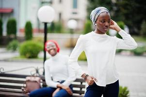 Two young modern fashionable, attractive, tall and slim african muslim womans in hijab or turban head scarf posed together. photo