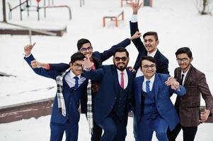 Group of six indian businessman in suits posed outdoor in winter day at Europe, hugs and happy emotions. photo