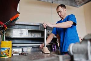 Prosthetist man making prosthetic leg while working in laboratory. photo