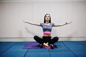 Young brunette sexy slim girl doing workout at gym. photo