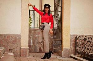 African american fashion girl in newsboy cap posed at street. photo