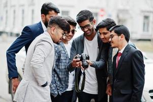 Group of six south asian indian mans in traditional, casual and business wear. Asia tourists looking at the dslr photo camera.