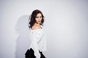 Studio portrait of brunette girl in white blouse on white background. photo