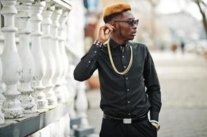 Chic handsome african american man in black shirt with gold chain and sunglasses. photo