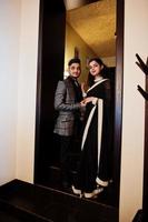 Lovely indian couple in love, wear at saree and elegant suit, posed on restaurant. photo