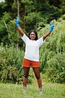 mujer voluntaria africana en el parque. Concepto de voluntariado, caridad, personas y ecología de África. foto