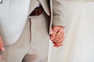 Bride and groom holding hands, close up. Their happy wedding day. photo