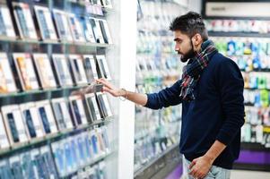 el comprador del cliente del hombre indio de la barba en la tienda de teléfonos móviles elige su nuevo teléfono inteligente. concepto de pueblos y tecnologías del sur de Asia. tienda de celulares foto