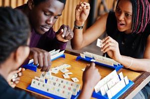 grupo de tres amigos afroamericanos juegan juegos de mesa. foto