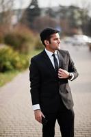 Elegant south asian indian business man in black suit. photo