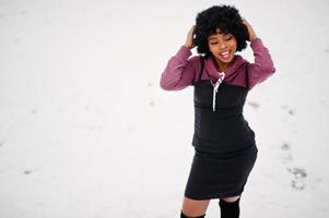 Curly hair african american woman posed at winter day. Afro model girl against snow. photo